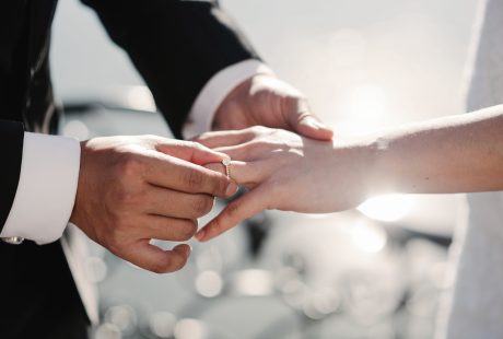 Mariée et marié tenant leurs alliances dorées lors du mariage civil, illustration du coût du mariage civil en Belgique