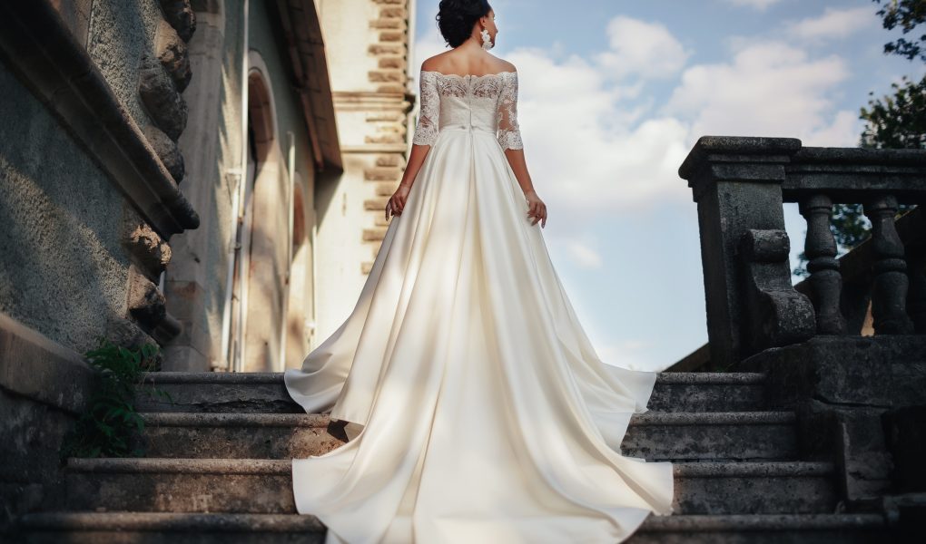Robe de mariée 2027 : mariée élégante en robe de créateur devant un château médiéval