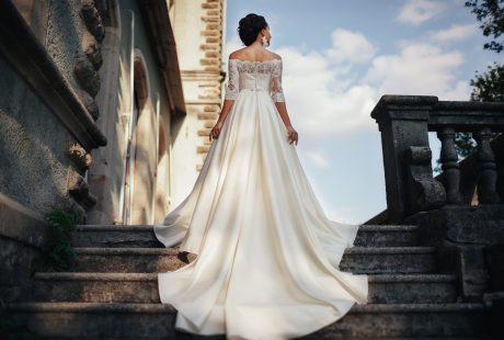 Robe de mariée 2027 : mariée élégante en robe de créateur devant un château médiéval